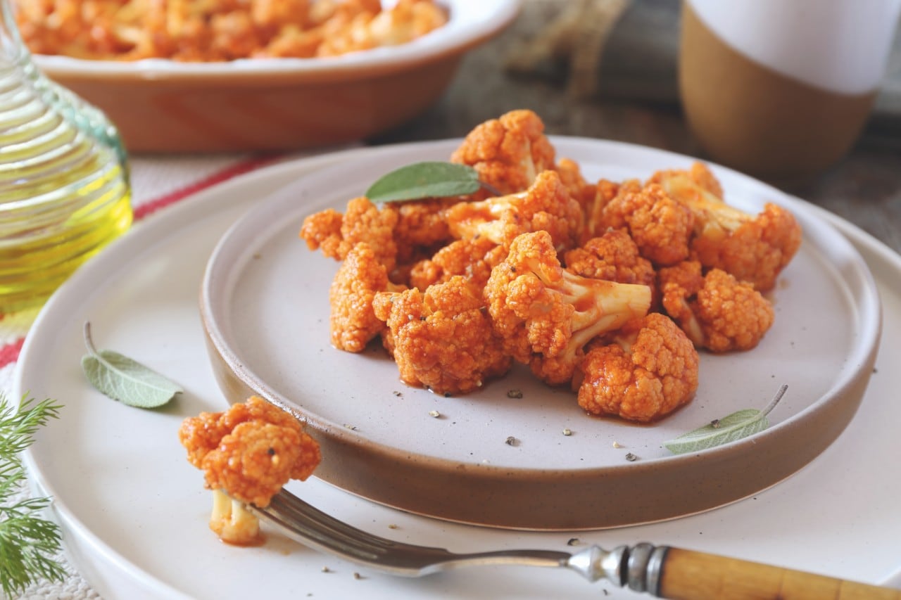 Vegetable vegetarian cuisine: spicy roasted cauliflower in tomato sauce and olive oil